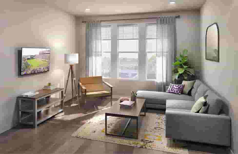 Student living room showing sofa, TV, and coffee table in Greenville