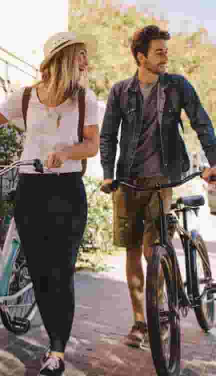 ECU students walking down the street with bicycles
