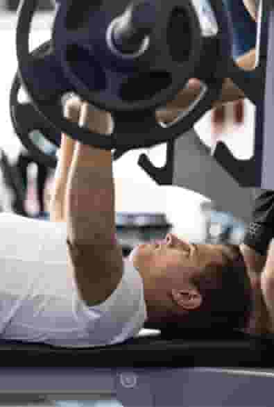 Student resident lifting weights in The Jolly Roger's Fitness Center